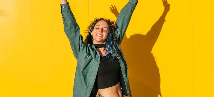 Una mujer se estira feliz frente al Sol / Westend61