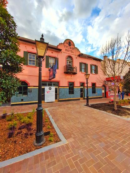 The Old Fitzroy Hotel, which is looking for a new owner. A charming salmon–coloured building with grey shutters.