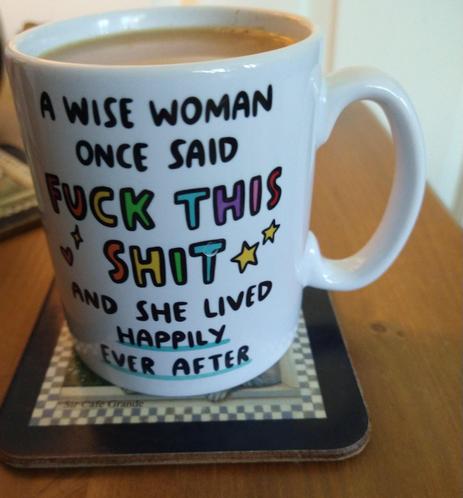 Mug of tea on a bedside cabinet, with the words ' A wise woman once said Fuck this shit and she lived happily ever after '