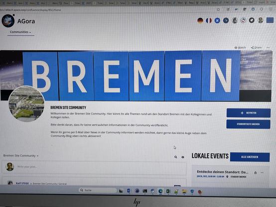 A screenshot of a community page titled "Bremen Site Community." The page features a large depiction of the word "BREMEN" in blue letters. There is an image of a facility, text welcoming users, and options to join or view events