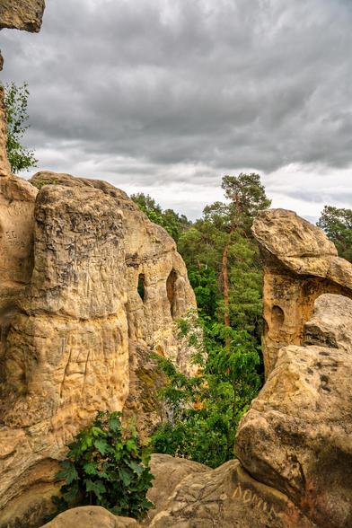 Sandstein Klippen Formationen. In einem der Sandsteinfelsen sind Öffnungen in dem natürlichen Raum im Felsen sichtbar. Über den Felsen ein Wolkenhimmel