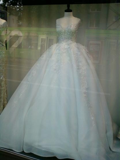 Ein weißes Brautkleid in einem Schaufenster.