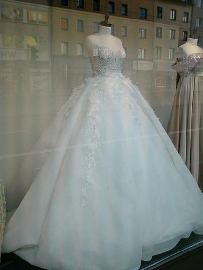 Ein weißes Brautkleid in einem Schaufenster.
