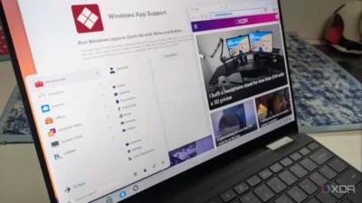 A laptop screen displaying Zorin OS with Windows App Support and a web browser showcasing tech news articles.