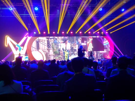 The opening plenary at Velo City 2025.  Big stage, big screen, lots of lights.