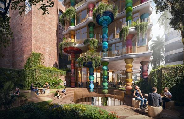 New building in Bogota that's designed round really bright colorful columns, with giant bowls on top filled with green. Outside courtyard with people sat in groups talking.