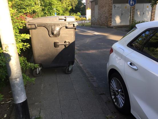 Restmüllcontainer versperrt gesamte Gehwegbreite und Zugang über abgesenkten Bordstein