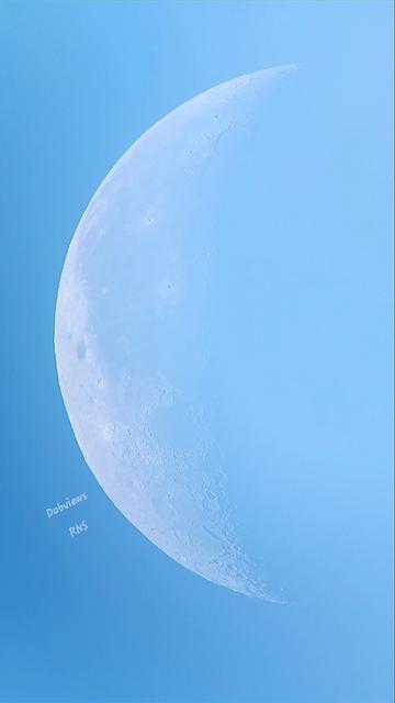 Set within a light blue sky the bright white and lighter blue surface of the waning moon creates a beautiful view of the 31.1% illuminated moon. The mountains and ridges are barely discernable across the surface... the depths of craters and valleys give a blue lace effect to its surface.