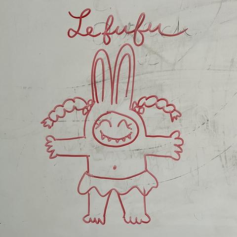 A whiteboard drawing of a cute humanoid creature wearing a bunny suit with pigtails and sharp teeth. The name, Lefufu is written above it.