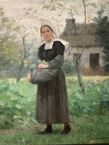 Détail d'une peinture où on voit une jeune femme, vêtue de l'habit breton (robe sombre, grand col blanc et coiffe blanche). elle a relevé son tablier pour y faire tenir des plantes et nous regarde. Autour d'elle, un jardin vert, quelques arbres et à l'arrière une maison. Les coups de pinceau sont visibles
Il s'agit d'une oeuvre d'Elin Danielson-Gambogi, une peintre finlandaise, intitulée Jeune Bretonne, datée de 1884