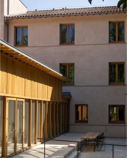 Timber pavillion added on an existing building retrofitted with straw insulation, plastered.