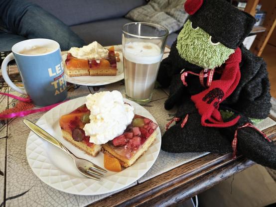 Joschka genießt Kuchen mit Sahne und Latte Macchiato