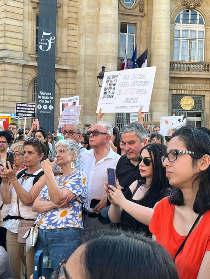 Photo d'une foule au rassemblement. Les gens tiennent des pancartes pour appeler à la fin de la guerre.