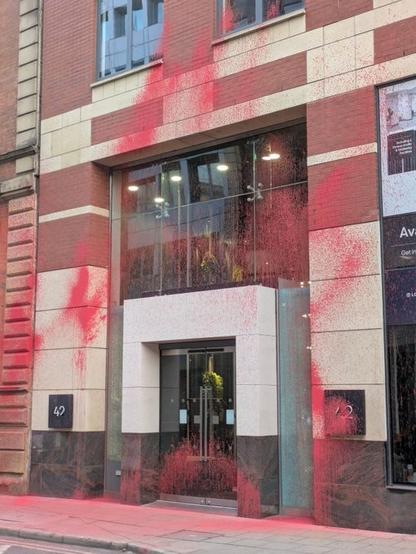 Picture of an office building in Manchester coered in red paint.