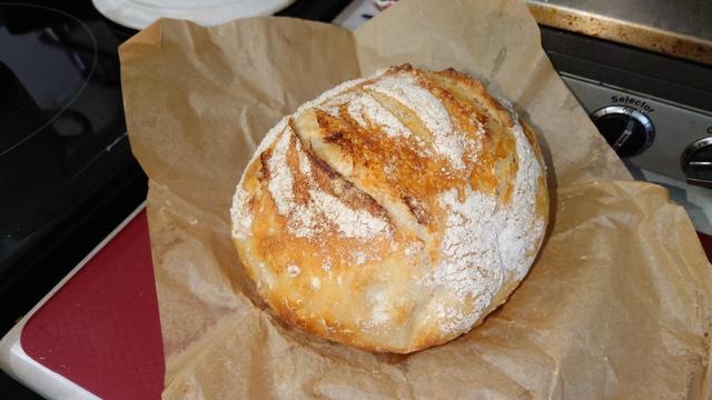 A loaf of sour dough bread on a cooling rack