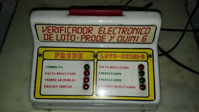 Verificador electrónico de boletas perforadas. Es una consola de plástico en forma de L, que en su parte superior tiene una ranura por donde se introducen las boletas. Abajo, unas lámparas se encienden o apagan de acuerdo a si la tarjeta es válida o tiene errores.

En la parte alta de la L se lee “Verificador eletrónico de Loto, Prode y Quini 6”. La parte de abajo se divide en dos marcos: uno para prode, el otro para loto y quini 6.