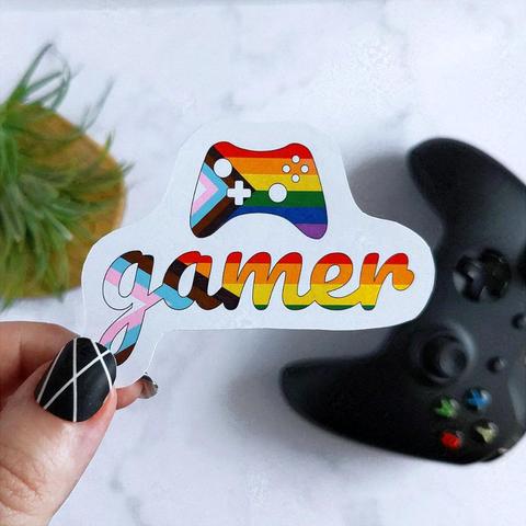 Sticker with the word gamer and a game controller on top, with the colors of the LGBTQ+ progressive flag.