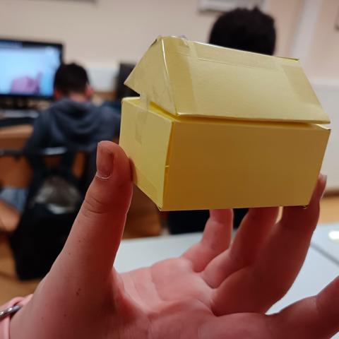 Solide représentant une maison avec un pavé droit et un prisme droit à base triangulaire comme toit.