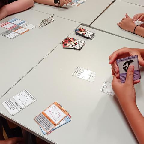 Table avec des mains d'élèves jouant au jeu de cartes get the square.