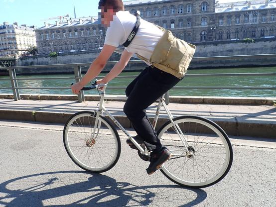 Cycliste avec un vélo Peugeot blanc avec des roues à jantes blanches.