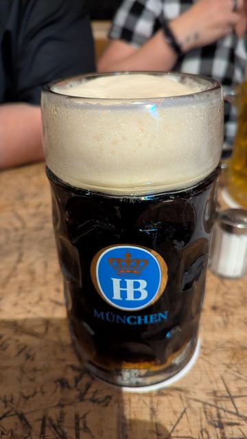 Ein Maßglas mit dunklem Bier und schöner Schaumkrone.