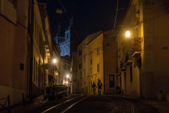 a couple walking down the street in Alfama neighborhood in Lisbon at 4am