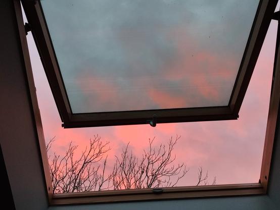 Photo d'un velux avec un ciel rose derrière