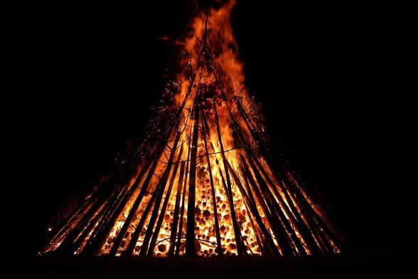night photograph of towering bonfire against darkness