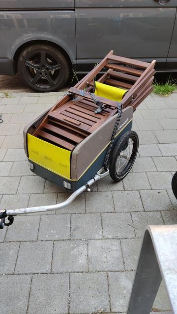 Fahrrad-Anhänger mit zwei IKEA Äpplarö Stühlen, die weit aus dem Anhänger herausragen.
