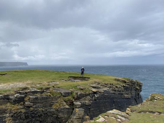 Dad birdwatching in the distance, near a steep cliff
