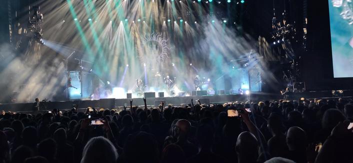 Behemoth op de North Stage op Graspop 2025. Het podium wordt verlicht met witte en cyane lampen. Op de voorgrond publiek dat bijna niet te zien is.