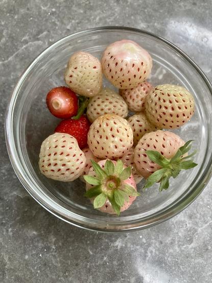 Stand red and alpine white strawberries in a glass bowl.