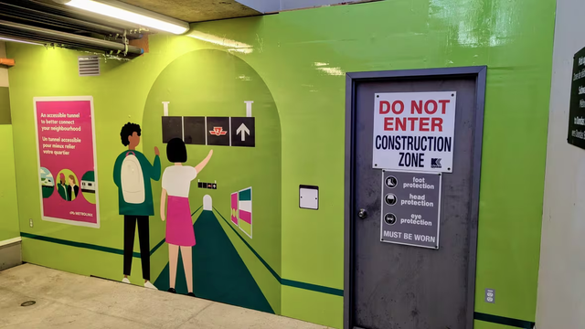 A colourful mural painted over hoarding blocking a construction zone at Dundas West TTC station. CBC caption reads: Signage at UP Express Bloor Station shows where the passenger tunnel to the Dundas West subway station will be when it opens.
