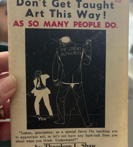 A book called “don’t get taught art this way! as so many people do” by Theodore Shaw. It features a cartoon of a large man with “the great authority“ written on his back attacking a small man labeled “you“