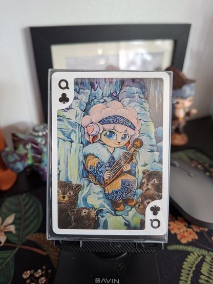 An artwork by Steffi ü called "Poppy Queen of Clubs," an animorphic sheep surrounded by 4 brown cubs.