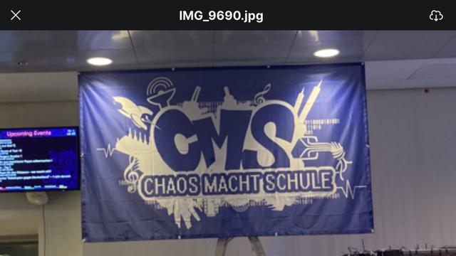 Es ist ein Banner/Flagge zusehen in den Farben Blau und Weiß auf dem Chaos Macht Schule steht