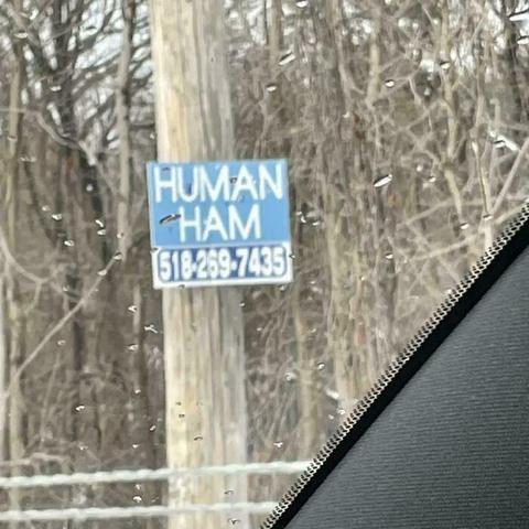 Sign that says "human ham" as well as a phone number