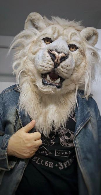 Ghost, a white lion, wearing a denim jacket in a casual pose, with one hand resting on the lapel