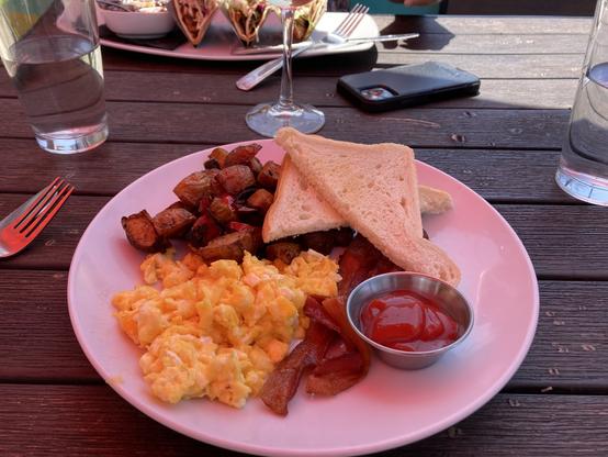 Scrambled eggs, bacon, potatoes and toast