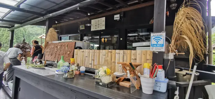 A bar counter with Japanese text indicating a restaurant offering soba, with a note about free Wi-Fi details beneath.