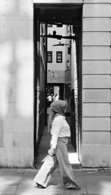 Woman passing a narrow alley.