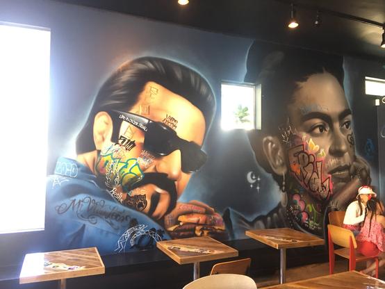 wall mural, two iconic celeb faces that I can't reliably place, deiberately tagged with graffiti. My alt text isn't doing it justice, perhaps the alttags folks can fill in.
