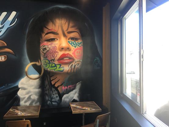 wall mura;, iconic celeb face that I can't reliably place, deiberately tagged with graffiti. My alt text isn't doing it justice, perhaps the alttags folks can fill in.