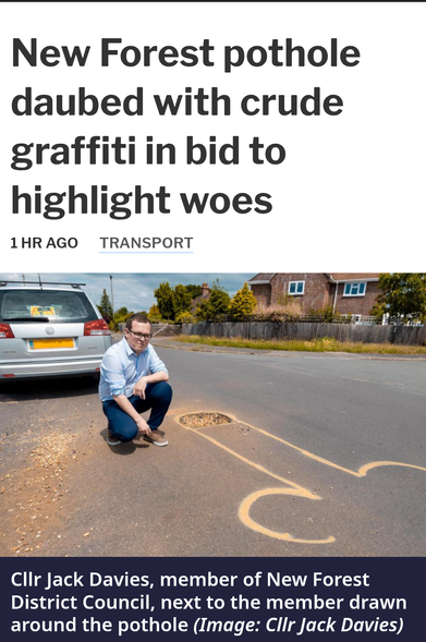Screenshot of local newspaper website article. Headline : "New Forest pothole daubed with crude graffiti in bid to highlight woes". Below, a photo of a man crouched in the road behind a silver car. He is crouching next to a pothole and looking at the camera. Around the pothole someone has painted, in yellow, a giant knob and testes. There are no representations of hair, and the end of the knob could not be properly completed because of the presence of the pothole. Photo caption reads "Councillor Jack Davies, member of New Forest District Council, next to the member drawn around the pothole" (plus an image credit(