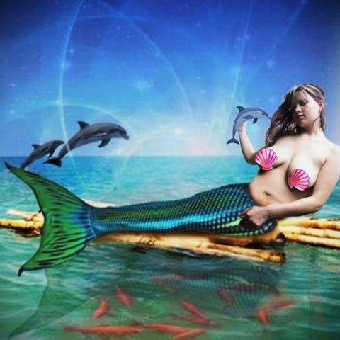 Das Bild zeigt eine merkurische Figur, die auf einem Baumstamm im Meer liegt. Die Figur hat ein menschliches Oberkörper und eine Meerjungfrau-Flosse, die in leuchtenden Blautönen mit grünen Akzenten schimmert. Sie trägt pinkfarbene Muschel-BHs. Im Hintergrund springen zwei Delfine aus dem Wasser, und im Vordergrund schwimmen rote Fische. Der Himmel ist blau mit leichten Wolken und einem leichten Glitzern, was eine magische Atmosphäre schafft. Die Farben sind lebendig und die Komposition harmonisch, was eine idyllische und faszinierende Szene erzeugt.