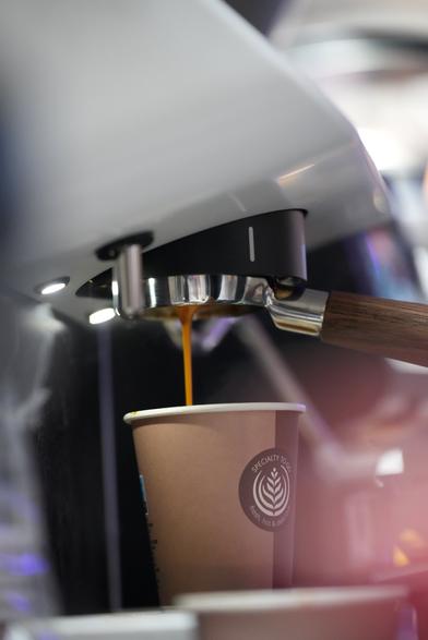 Kaffee läuft aus der Siebträgermaschine in einen Becher