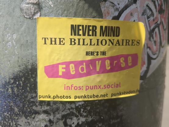 Sticker on  a lamp-post reading "Never mind the billionaires - here's the fediverse. Info's: punx.social." The sticker uses black, yellow and pink and clearly imitates the cover from the Sex Pistols album, 'Never mind the bollocks'.