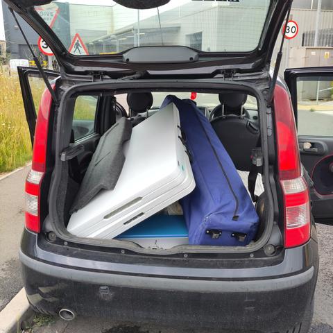 A very small car with a lot of large items fitting into the boot somehow
