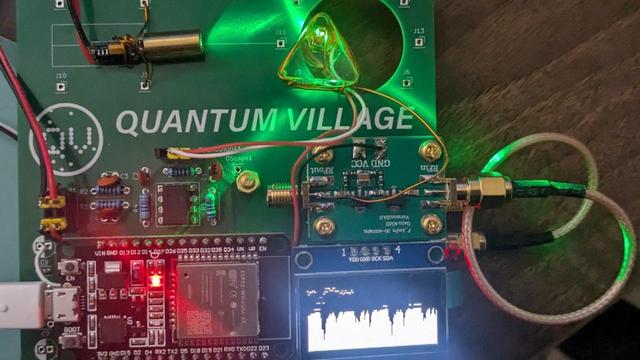 [ImageSource: Quantum Village]

Building a practical version of this quantum sensor isn’t as difficult as it sounds. The trickiest part seems to be building the diamond assembly, which has the N-V diamond [about the size of a grain of sand and actually not that expensive] potted in clear epoxy along with a loop of copper wire for the microwave antenna, a photodiode and a small fleck of red filter material. The electronics primarily consist of an ADF4531 phase-locked loop RF signal generator and a 40-dB RF amplifier to generate the microwave signals, a green laser diode module and an ESP32 dev board.

<https://quantumvillage.org/>

All the design files and firmware have been open-sourced, and everything about the build seems quite approachable. The write-up emphasizes Quantum Village’s desire to make this quantum technology’s [Apple II moment], which we heartily endorse. I’ve seen N-V sensors detailed before, but this project might make it easier to play with quantum physics at home.