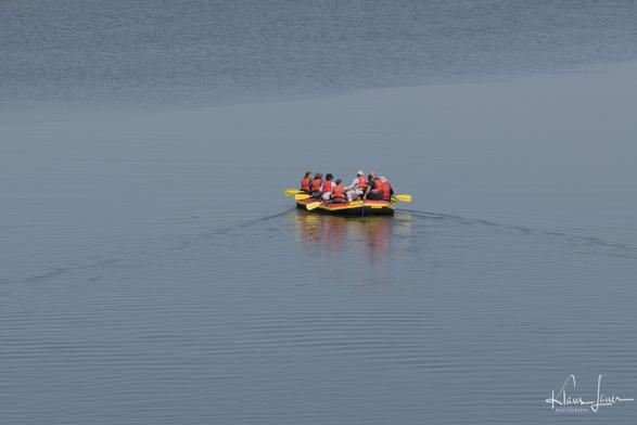 Rafting-Schlauchboot auf dem toten Arm. Das Boot ist mit 8 Personen in Rettungswesten besetzt.